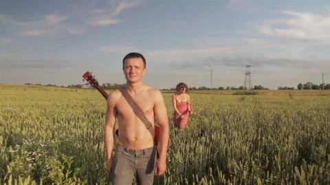 A young couple is walking along the wheat field. Video stock 78700270