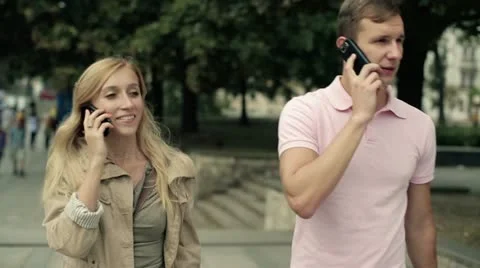 Young couple walking and talking on cellphone in the city, steadicam shot HD Stock Footage 11883984