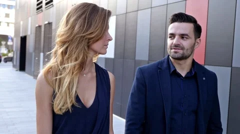 Young couple  walking and talking in front of modern building. Romantic meeting. Stock Footage 55893269