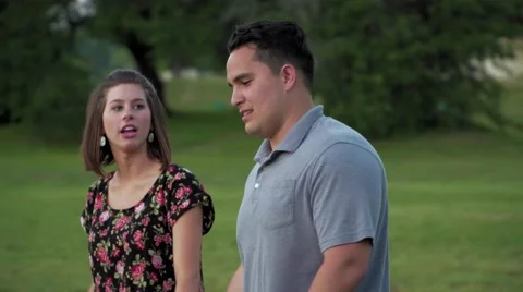 Young couple walking and talking in a park Stock-Footage 64340126