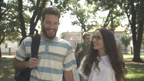 Young couple walking and talking, close up, boys and girls passing in the park. Stock Footage 97700863