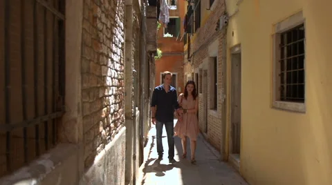 Young couple walking in the back streets of Venice Stock Footage 40106356