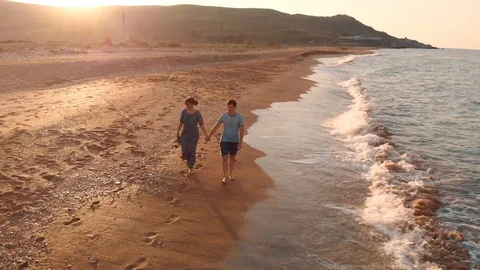 Young couple walking on beach Stock Footage 99276443
