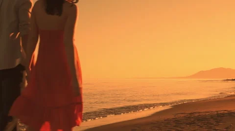 Young couple walking on beach in sunset. Stock Footage 43663290