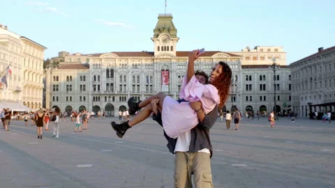 Young couple walking in big square piazza unità in trieste taking selfie Stock Footage 235380213