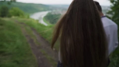 The young couple walking down to the river shore. slow motion, soft focus Stock Footage 214439353