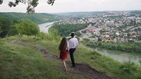 The young couple walking down to the river shore. slow motion, wide shot Stock Footage 221017522