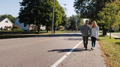 Young couple walking down the street holding hands. Typical American city Stock Footage 83001436