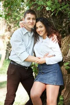 Young couple walking in the forest, posing near tree, summer nature, bright s Stock Photos