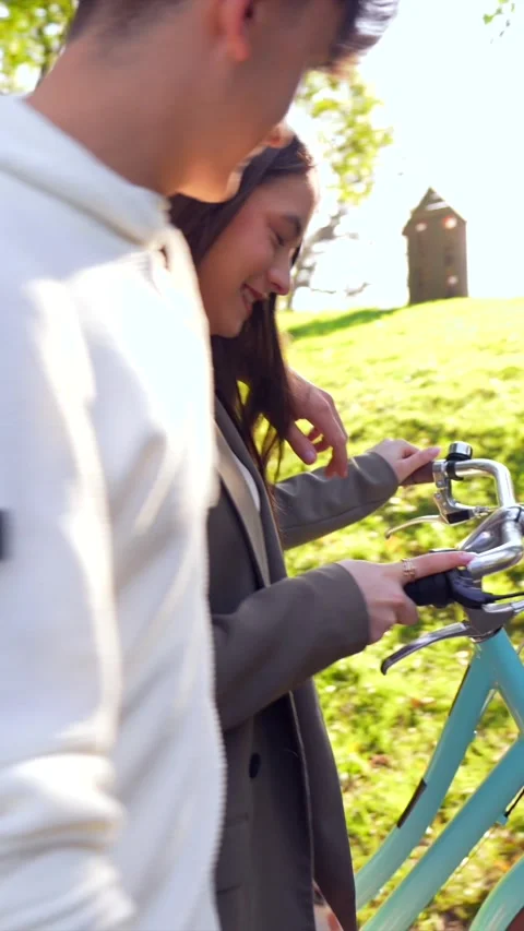 Young couple walking in park with bicycle Stock Footage 303484995