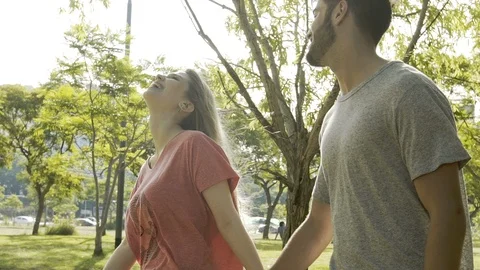 Young couple walking in park Stock Footage 106316488