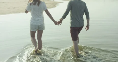 Young couple walking by the river and holding hands Stock Footage 99098230