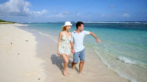 Young couple walking on a sandy beach Stock Footage 37815541
