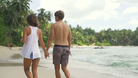 Young couple walking on sandy beach sunny day rapid slow motion Stock Footage 84820947