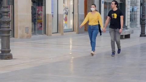 Young couple walking in the streets with face masks Video stock 129616876