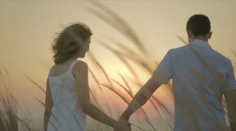 Young couple walking in sunset Stock Footage 10843655