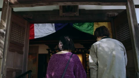 Young couple walking up to a temple and praying in front of a statue through the Video stock 199460109
