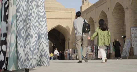Young couple walking together through Uzbek national souvenirs and gift shops in Stock Footage 272811409