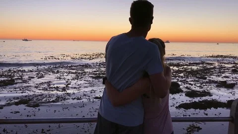 Young couple walking towards sunset horizon Stock Footage 76521596