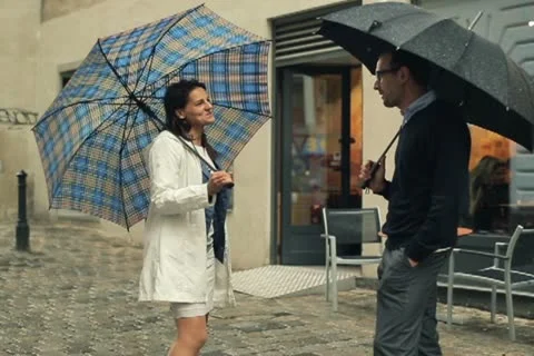 Young couple walking with umbrella in the city, steadycam shot Stock Footage