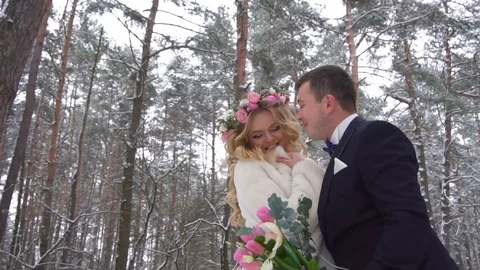Young couple walking in winter forest holding hands and embracing in slow motion Stock Footage 83019186