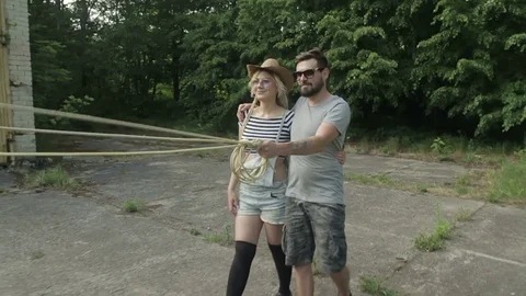 A young couple is walking with zombies on leashes. Slow motion. Video stock 77489558