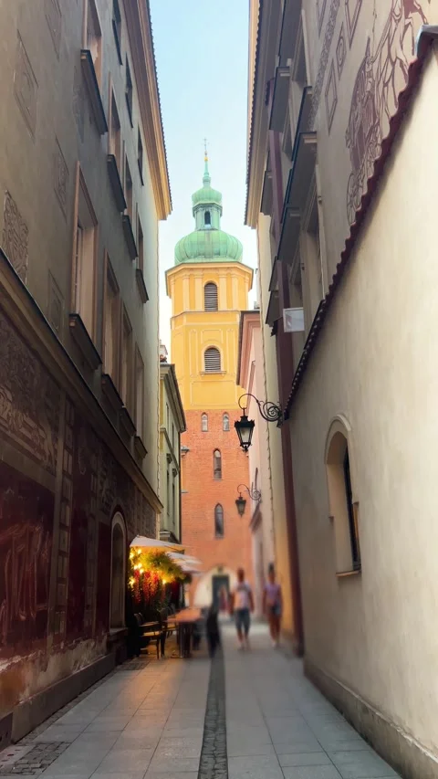 A young couple walks down a narrow cobblestone alley in Warsaw. Stock Footage 346367078