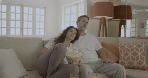 Young couple watch dramatic television scenes together. Stock Footage 232435575