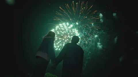 Young Couple Watching Beautiful Fireworks. Silhouette of people watching Stock Footage