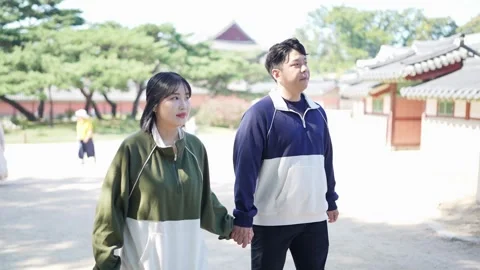 A young couple wearing jerseys is taking a walk in a park with historical Video stock 292483339