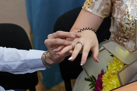 Young couple at the wedding exchanges engagement rings Stock Photos