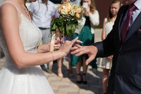 Young couple at the wedding exchanges engagement rings Stock Photos