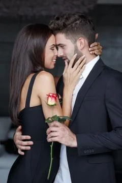 Young couple whispering love to each other on dating Stock Photos