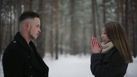 Young couple in the winter forest. Man girl warms his hands with his breath Stock Footage 73043502