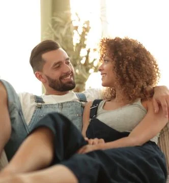 Young couple in work clothes sitting on couch Stock Photos