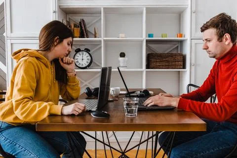 Young couple working at home in the same room. Stockfoto's