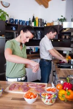 Young couple working in kitchen Stock Photos