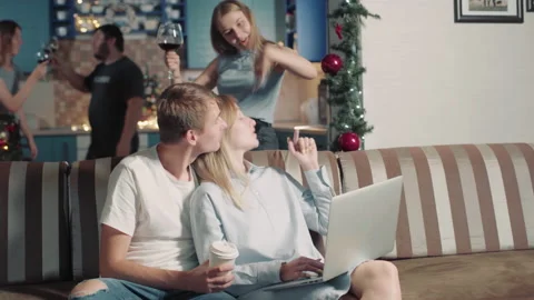 Young Couple Working Online While Group Friends Have Fun Celebrate Christmas. 库存影片 142658768