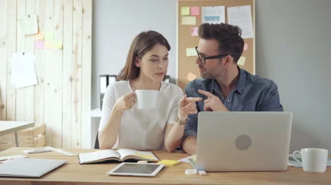 Young couple working together in creative agency. Discussing new project on l Stock Footage 64654680
