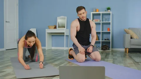 Young Couple Is Workouting at Home Watching Online Training Video Stock Footage 129745438