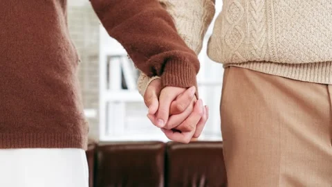 Young couples in cozy sweaters gently hold hands, celebrating love and connect Stock Footage 325708264