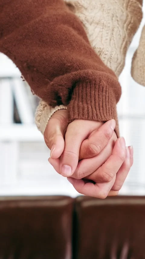Young couples in cozy sweaters gently hold hands, celebrating love Stock Footage 328076884