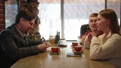Young couples raise hands together animatedly during friendly conversation at Stock Footage 322094849