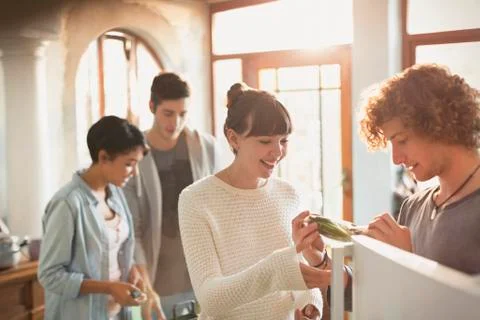 Young couples roommates cooking in kitchen Stock Photos