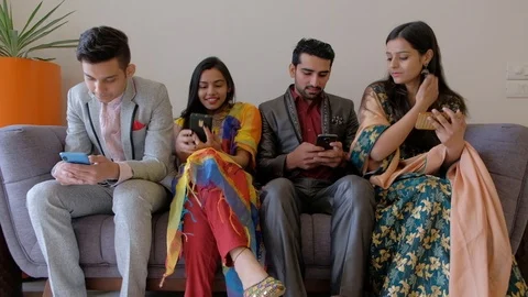 Young couples on a sofa couch addicted and fixed with their smart hone on wifi i Stock Footage 101225044