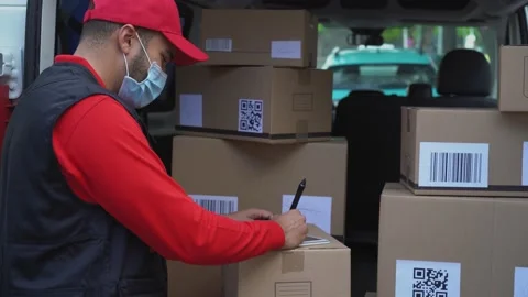 Young courier man writing on tablet informations about delivery packages Stock Footage 145434693