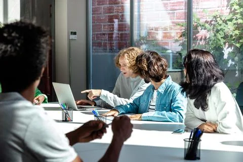 Young coworkers sharing progress at work. Stock Photos