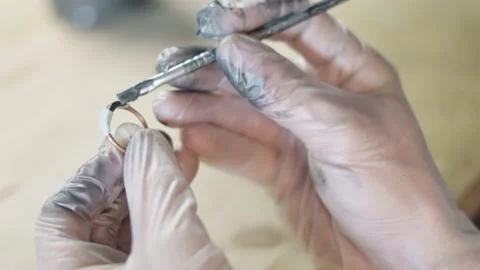 Young craftsman makes copper earrings and jewels. Видео 218503166