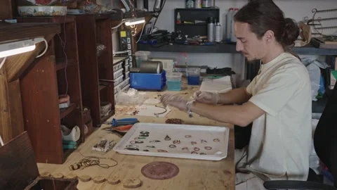 Young craftsman makes copper rings and jewelry. Видео 218504904