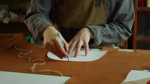 A young craftsman is thinking about creating a new pair of leather shoes for his Stock Photos